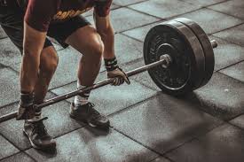 A builder is lifting up the weight.