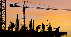 people working long hours on construction site in evening