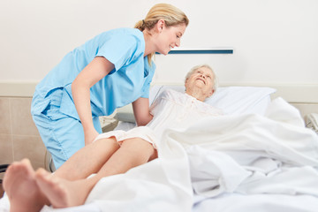 Photo of a nurse helping a bedridden patient