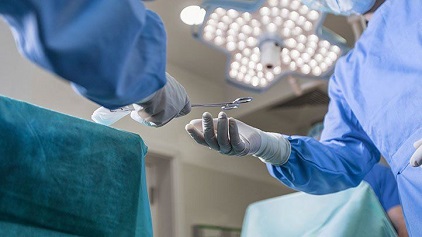 close up shoot of doctor taking scissor from nurse during surgery 