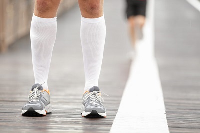 Running shoes closeup and compression socks on male runner. 