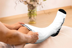 picture of a nurse trying to wear white compression socks 