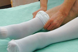 picture of a nurse wearing a pair of knee-high white compression socks 