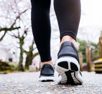 a close-up view of someone's legs and feet while out exercising in the street