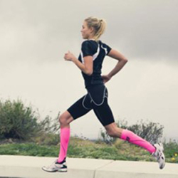 an athlete wearing a pair of bright colored pink socks while running outdoors