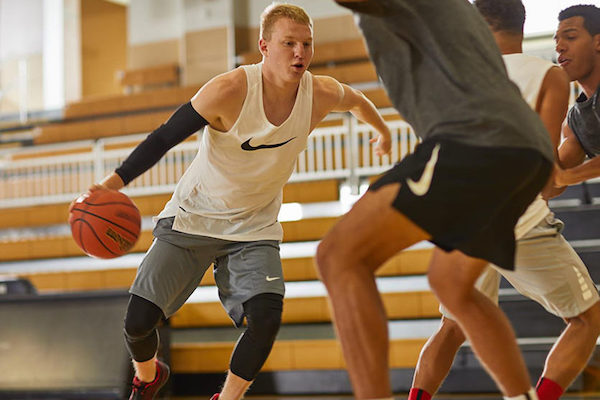 Basketball player wearing compression leg sleeves/leg compression sleeves while playing basketball to avoid potential leg injury and reduce muscle swelling and soreness