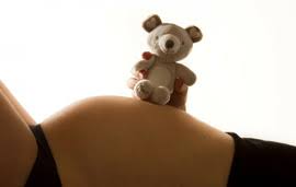 Pregnant woman holding a teddy bear