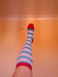  An image of a leg raised wearing a colorful stripped socks