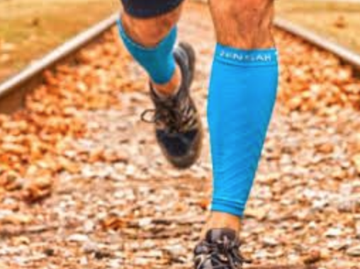 Man running in a pair of blue compression leg sleeves/leg compression sleeves