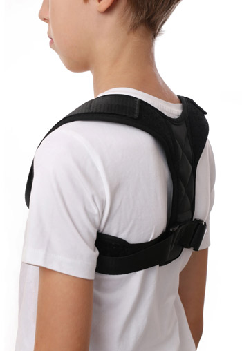 a young boy wearing a back brace on top of his white t-shirt