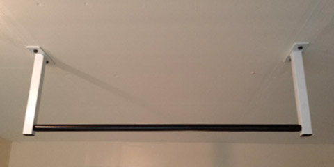 This image is of a ceiling mount in which the pull up bar suspends from the ceiling, with support of two rods or chains that hold it.