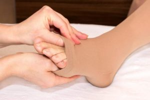 Image showing a doctor checking toes in open toe compression socks