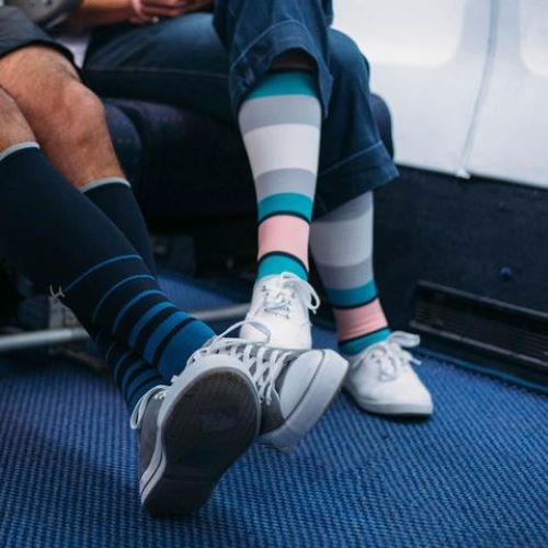 a man and woman wearing compression socks on an airplane