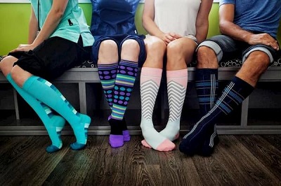 picture of men and women wearing knee-high compression multicolored socks 