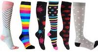 Several compression stockings shown. Pink and grey chevron pattern, bright colored stripes featuring bright pinks and blues, black socks with bright colored paint splotches, spotted and sriped pastel colors, black with red hearts, and grey with white spots.