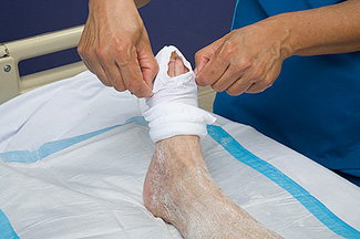  A nurse helping a patient donn pressure stockings