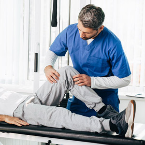 Medical professional stretching a man's leg