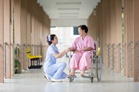 A nurse squats next to a patient in a wheelchair. Her compression stockings help keep her legs energized by preventing swelling and tiredness and improving circulation.