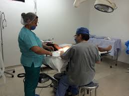 Nurse working on a patient in a hospital operating room. Wearing compression socks helps support blood flow in his legs during a long shift.