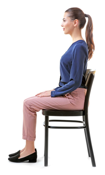 woman demonstrating how to sit properly with her back straight and her feet flat on the floor