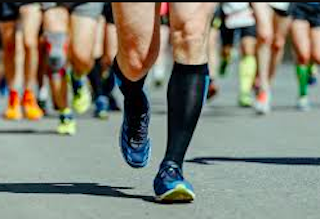 athletes run on the track wearing extra large compression socks