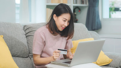 Woman holding her credit card while shopping online