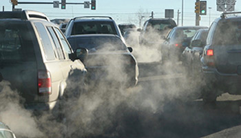 Picture of multiple cars in traffic with smoke coming from their exhaust and significant ground level pollution around all the cars. A car air purifier with HEPA filters and activated carbon filters can filter pollution and allergens and dust. Common brands of vehicle air purifiers are iqair, nuvomed, philips, and coconut air. Budget options are available too.