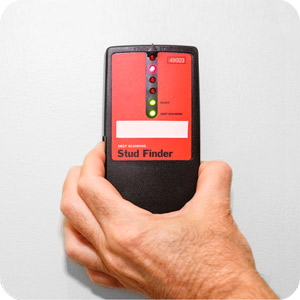 Man holding a Stud Finder that is switched on