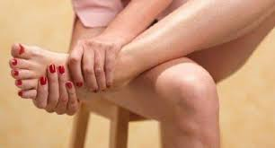  A woman massaging her swollen ankle (a pregnancy condition)