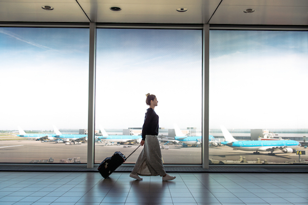 Photo of woman walking with her luggage at the airport